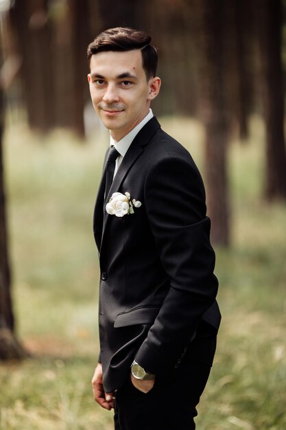 Handsome and funny groom posing in nature grooms portrait wedding day concept