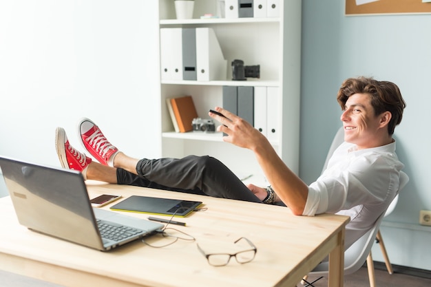 Handsome funny man in white shirt has a rest sitting at the office