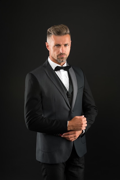 Handsome groom man wear tuxedo black background, wedding day concept.