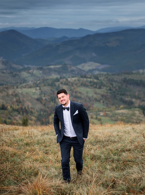 The handsome groom walking along field