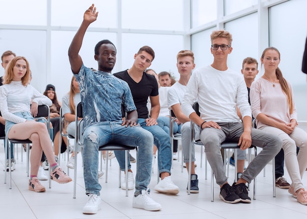 Handsome guy asking questions to the speaker at a group meeting