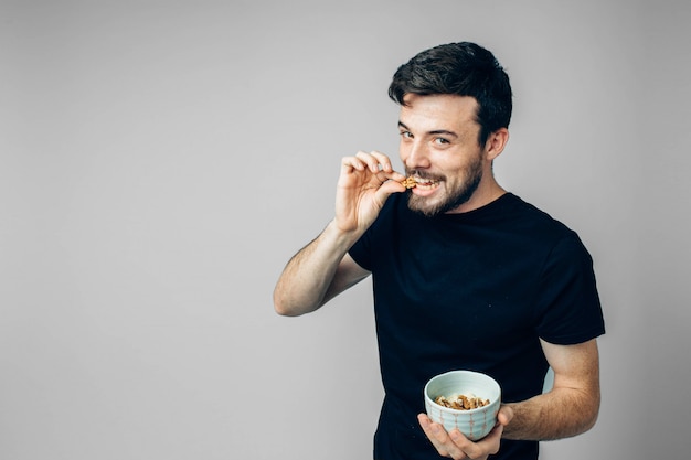 handsome guy biting walnut and posing on camera