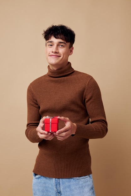 Handsome guy brown turtleneck posing fashion small gift box light background unaltered