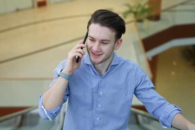 Handsome guy businessman is talking on cell mobile phone having conversation on smartphone calling