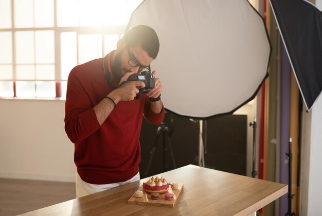 Foto fotografo di food blogger di bel ragazzo che scatta foto di torta