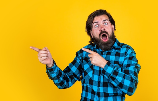 Bel ragazzo hipster con baffi e barba che punta il dito