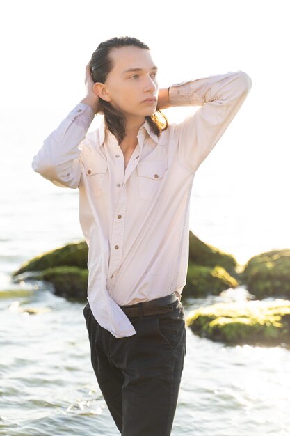 Handsome guy posing on the background of the ocean coast