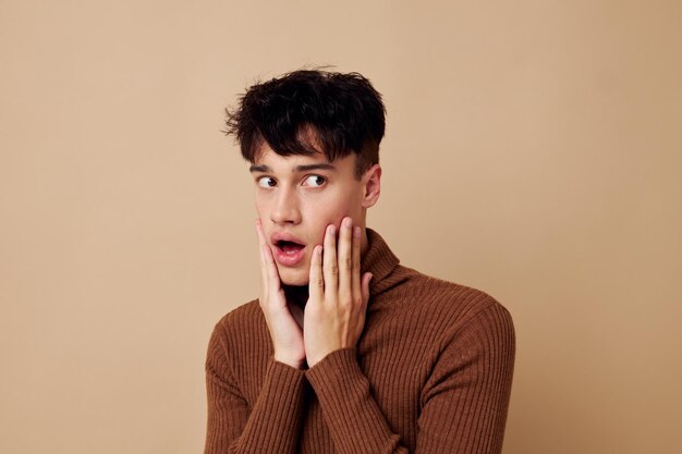 Handsome guy posing in brown sweater self confidence fashion isolated background unaltered