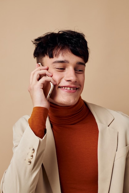 Handsome guy posing with a phone in his hands in a jacket elegant style Lifestyle unaltered