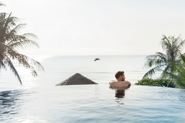 Handsome guy relaxing in swimming pool