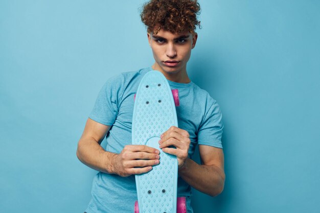 Handsome guy skateboard in hand in blue tshirts Lifestyle unaltered