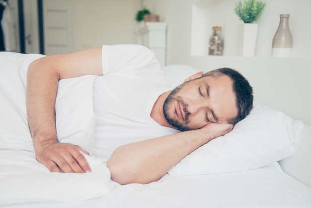 Handsome guy sleeping in his bedroom