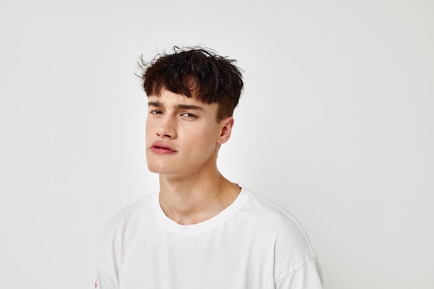 Handsome guy tattoo on hands in white tshirt light background unaltered