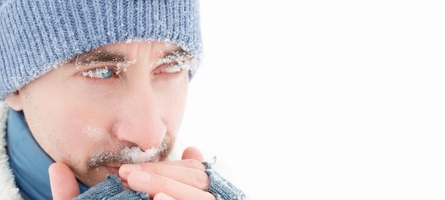 Handsome guy with blue eyes Snowflakes on the face Winter portrait Copy space