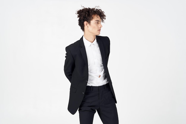 Handsome guy with curly hair and in a jacket shirt pants model High quality photo