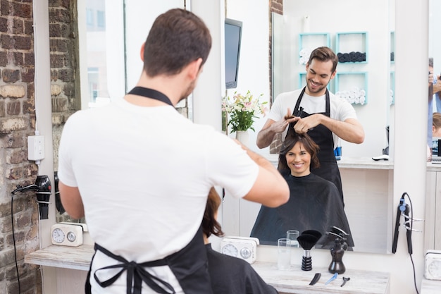 Handsome hair stylist with client