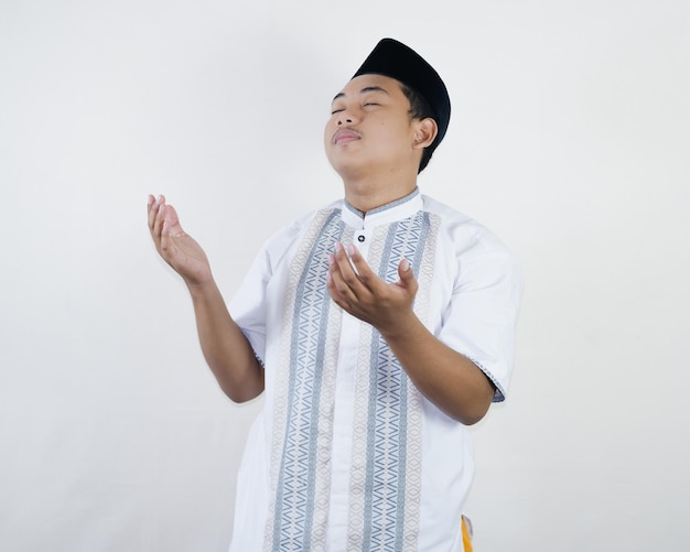 Красивый счастливый азиатский мусульманин молится Богу