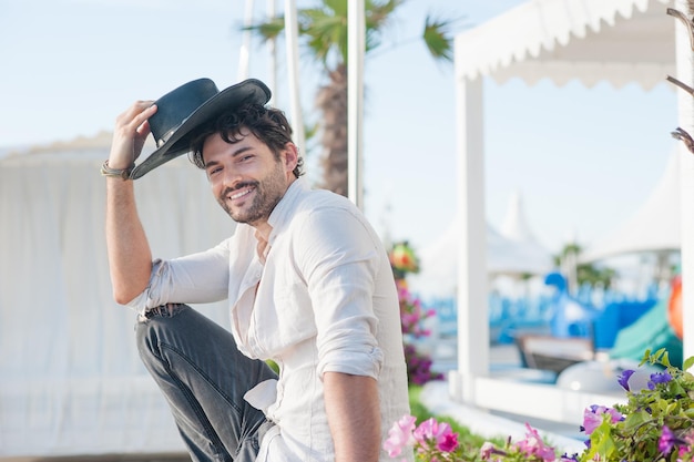 Handsome happy man dressed in black hat and white shirt