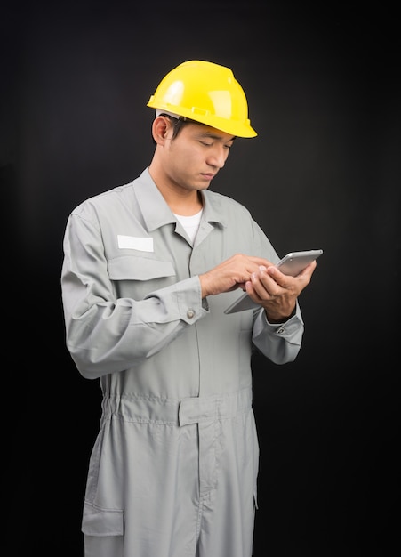 Handsome happy supervisor or technician worker with digital tablet on black 