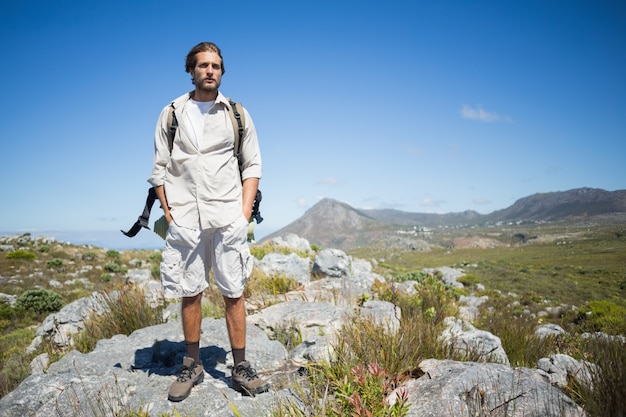 Handsome hiker standing at the summit 