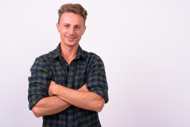  handsome hipster man with blond curly hair wearing green checkered shirt against white wall