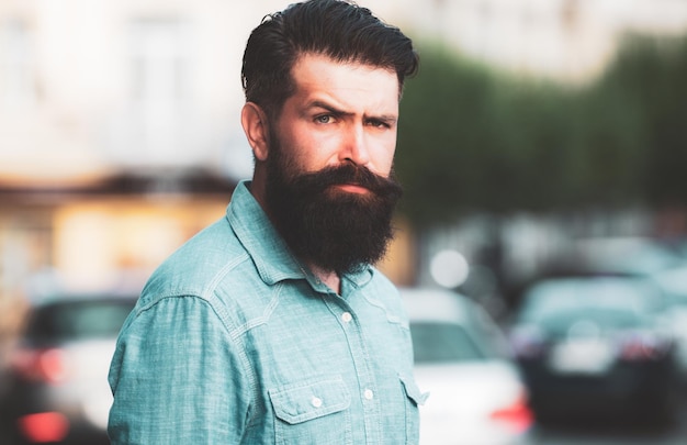 Handsome hipster modern businessman with beard walking in town.