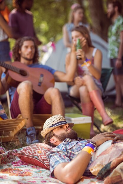 Handsome hipster relaxing on campsite