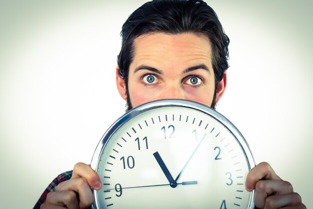 Handsome hipster showing a clock