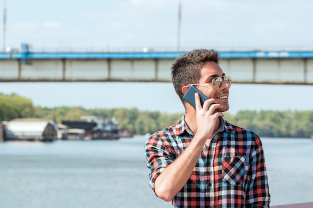 Photo handsome hipster talking on the phone .