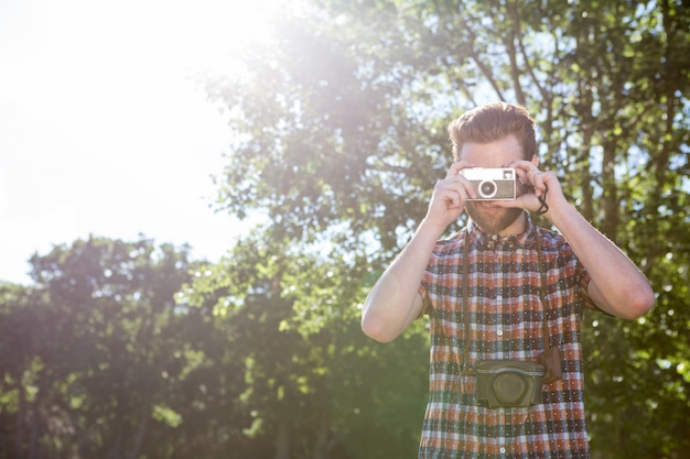 Handsome hipster using vintage camera