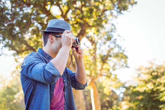 Handsome hipster using vintage camera