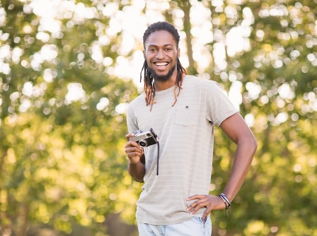 Handsome hipster using vintage camera