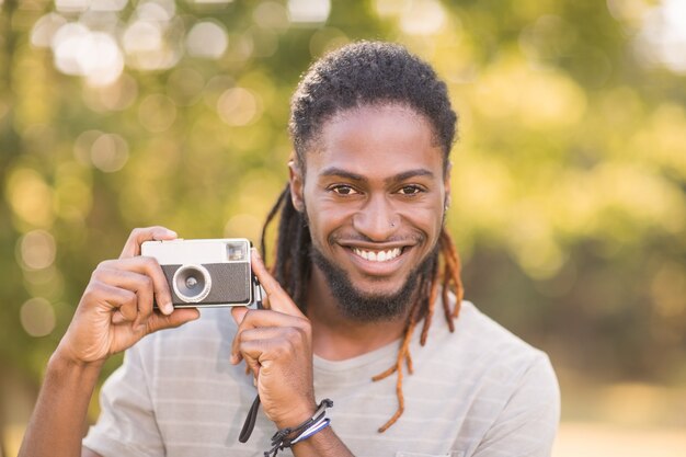 Handsome hipster using vintage camera