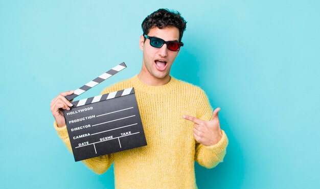 Handsome hispanic man feeling happy and pointing to self with an excited cinema concept