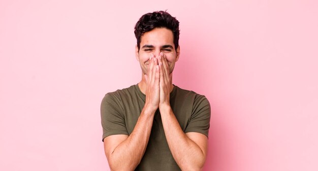 Handsome hispanic man looking happy cheerful lucky and surprised covering mouth with both hands