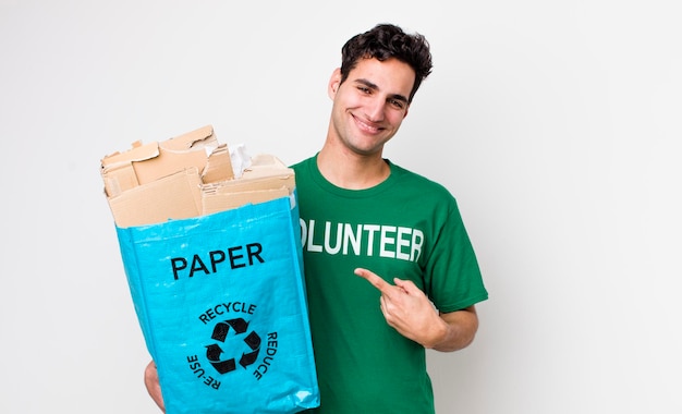 Handsome hispanic man smiling cheerfully feeling happy and pointing to the side ecology concept