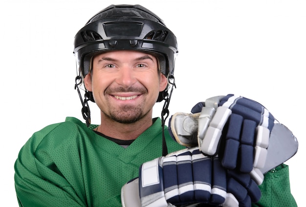 Handsome hockey player is smiling at camera.