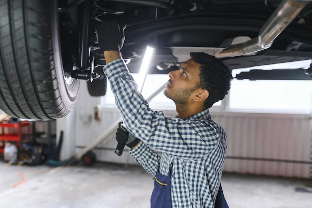 車サービスでハンサムなインドの自動車整備士