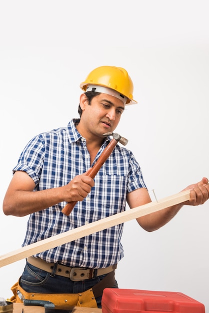 Handsome Indian Carpenter or wood worker in action, isolated