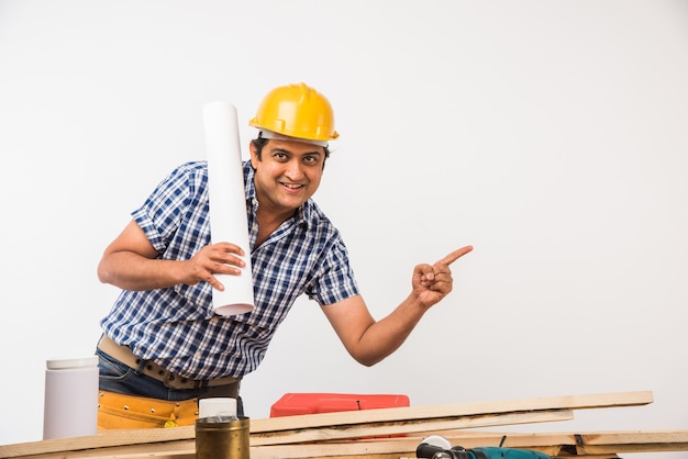 Handsome Indian Carpenter or wood worker in action, isolated