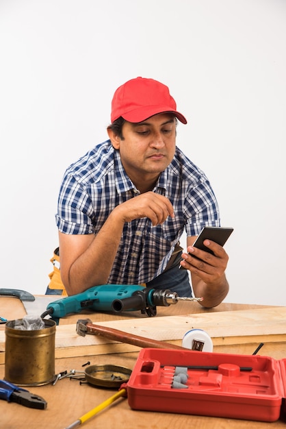 Handsome Indian Carpenter or wood worker in action, isolated