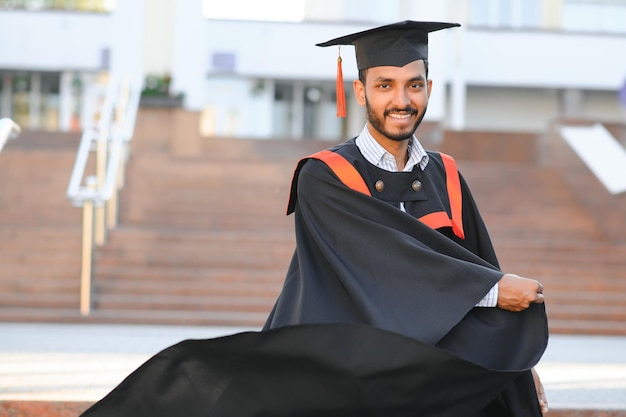 Foto bel laureato indiano in bagliore di laurea con diploma