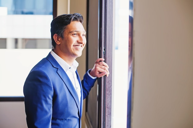 handsome indian man looking in a window