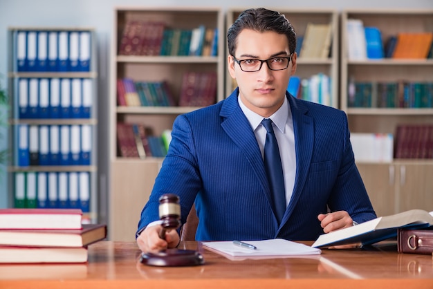 Foto giudice bello con il martelletto che si siede nell'aula di tribunale