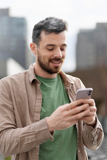 Photo handsome latin man holding smartphone using mobile app shopping online on the street