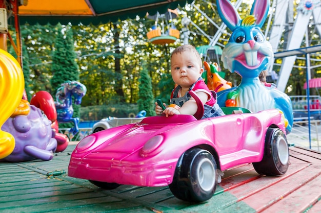 Ragazzino bello sulla macchina del giro di divertimento