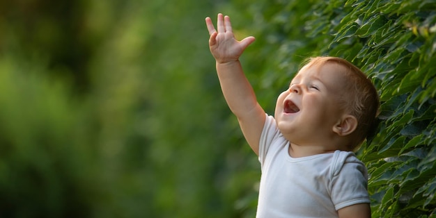 芝生の上に座って陽気なハンサムな男の子