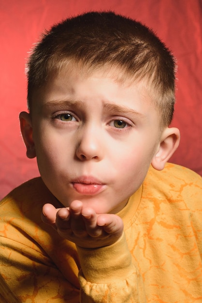 Handsome little boy showing hands a gesture of air kiss