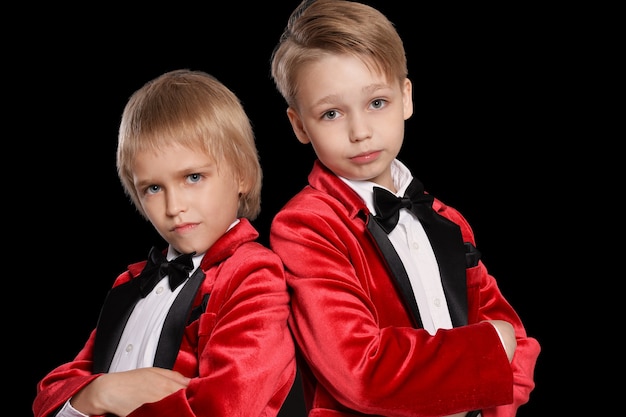 Handsome   little boys in a tuxedo on black background