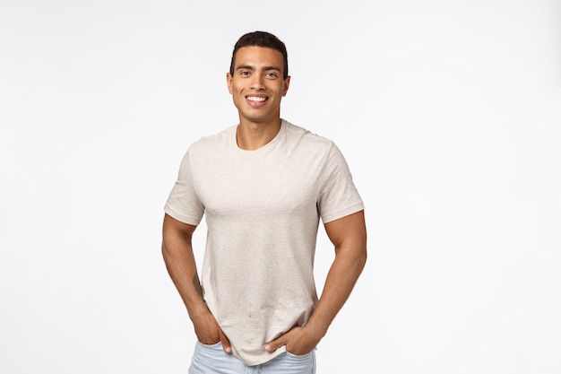 Photo handsome male athlete in casual t-shirt, hold hands in pockets and smiling with happy